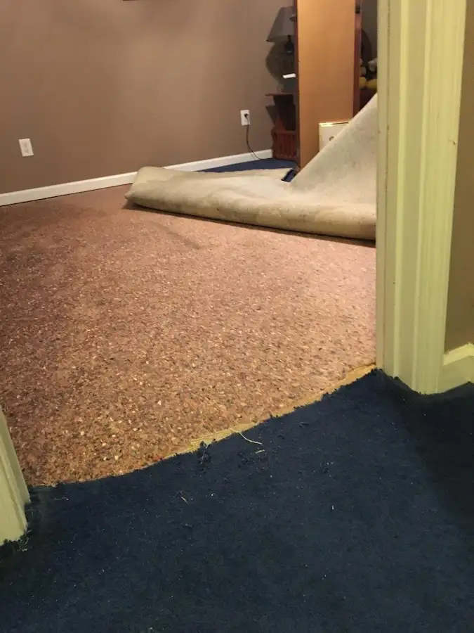 Carpet pad removal revealing water damage during Water Mitigation Services in Laie